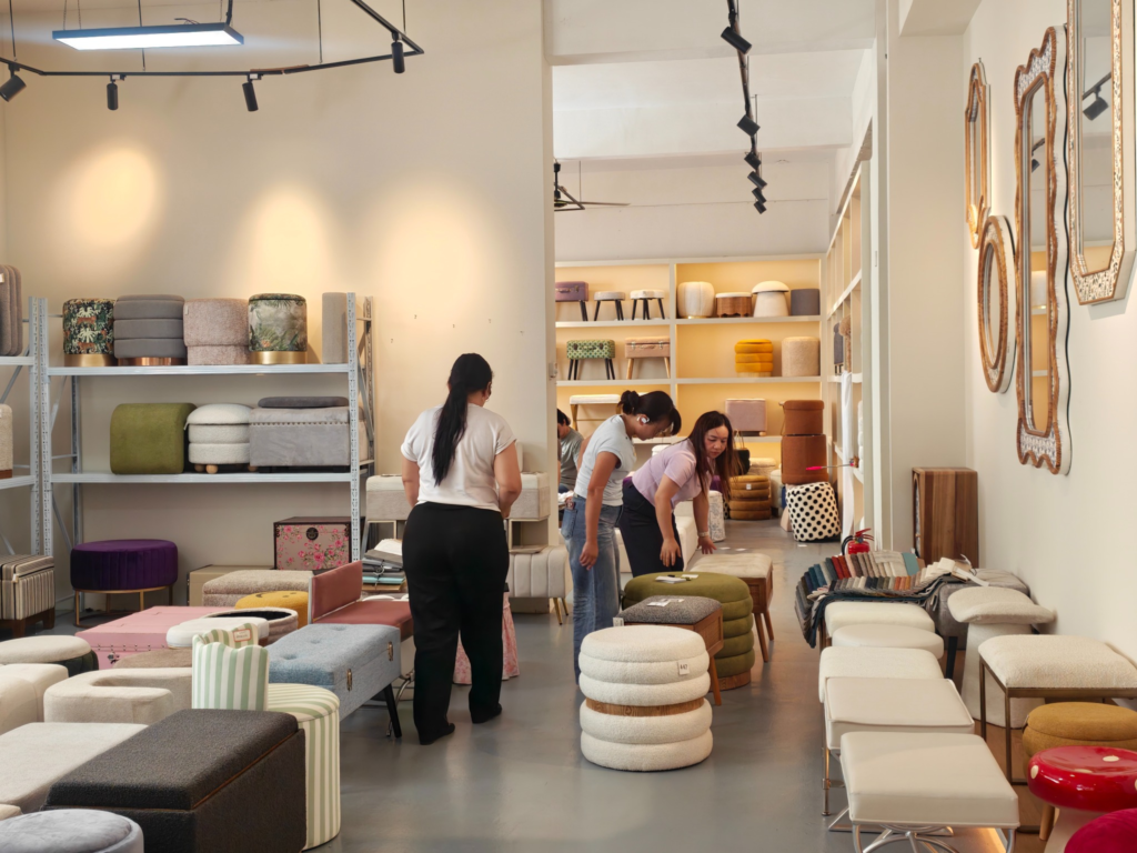 Buyers reviewing upholstered stools, ottomans, and benches in Teruier’s showroom.