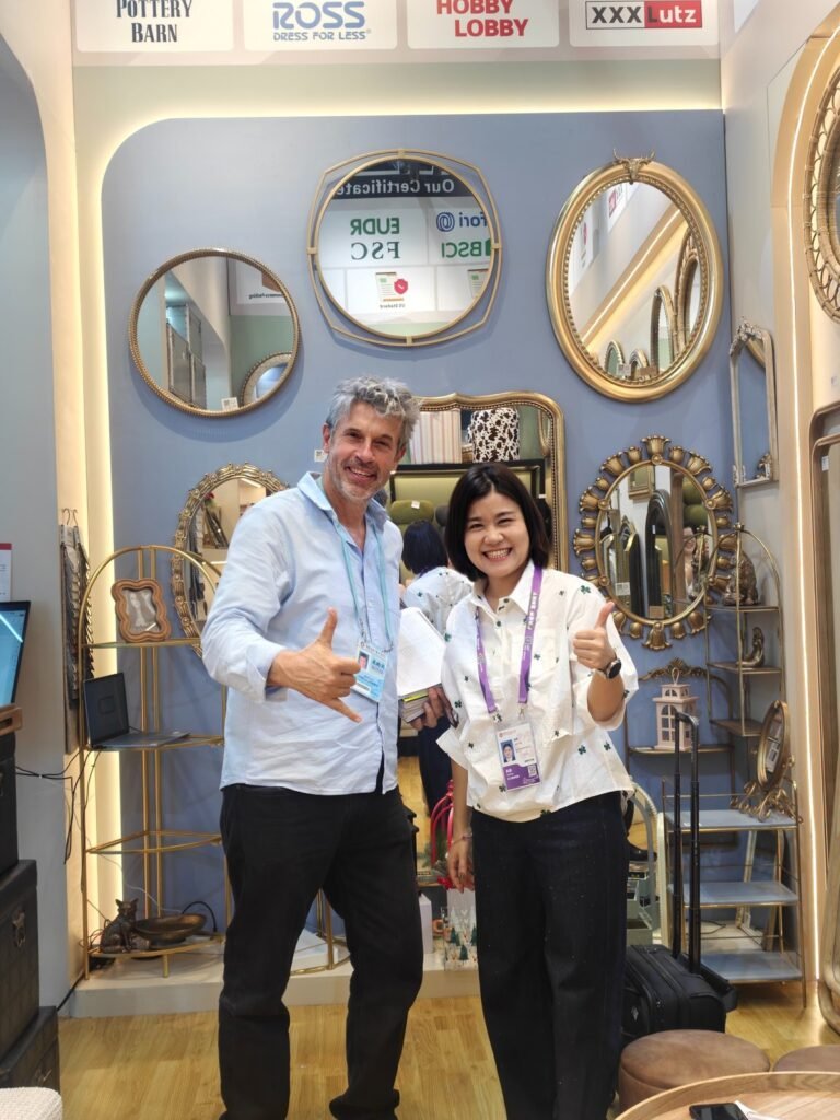 Two trade fair attendees posing for a photo in front of Teruier's decorative mirror display at the 2026 Canton Fair.